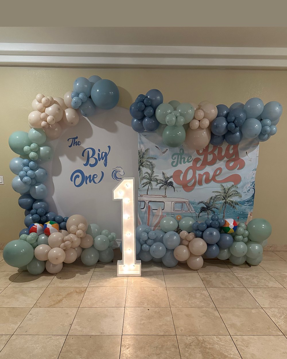 First birthday beach theme with two panels, a light-up number one and blue, sage and cream balloons